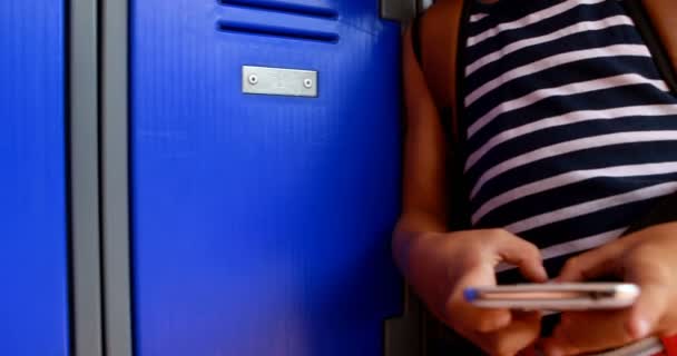 Schoolgirl using mobile phone in locker room — Stock Video