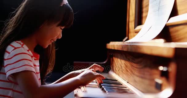 Школьница учит фортепиано в музыкальном классе — стоковое видео