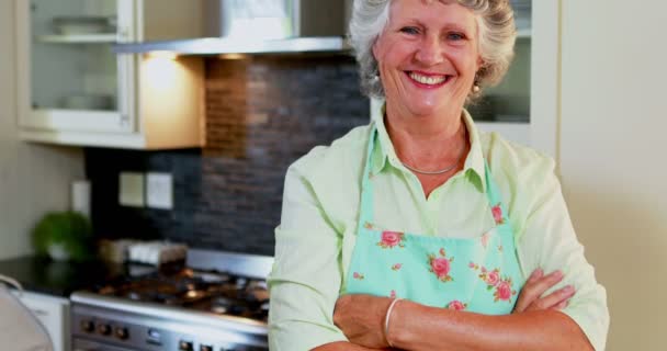 Старшая женщина, стоящая со скрещенными руками на кухне — стоковое видео