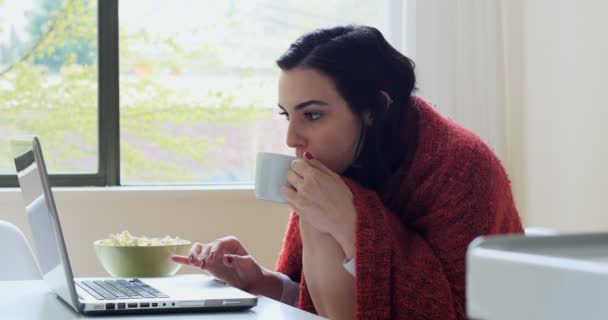 Hermosa mujer usando el ordenador portátil mientras toma café — Vídeo de stock