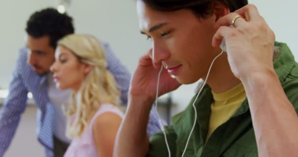 Executive hallgat zenét a fejhallgatót pult — Stock videók