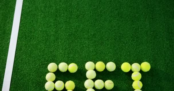 Palle da tennis formando parola impostata in campo — Video Stock