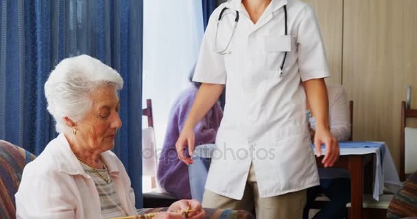 Médico femenino que interactúa con una mujer mayor — Vídeos de Stock