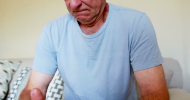 Sad senior man sitting on bed — Stock Video