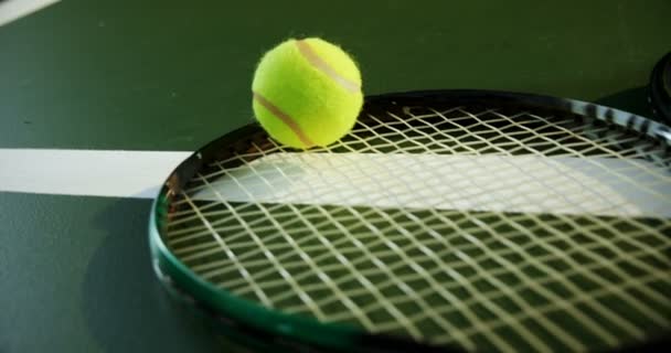 Raqueta y pelota de tenis en pista — Vídeos de Stock