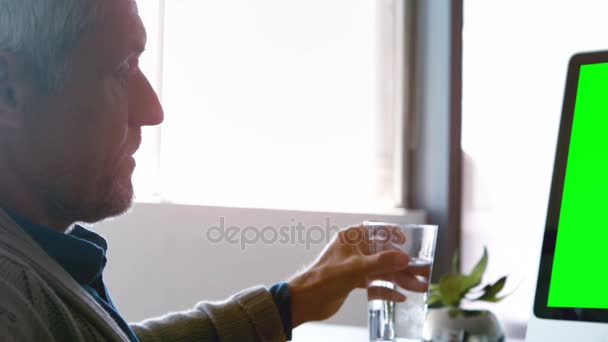 Agua potable ejecutiva masculina mientras se trabaja en PC de escritorio — Vídeos de Stock