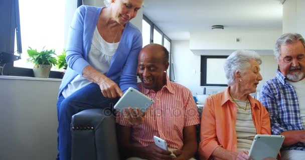 Amigos seniores felizes usando tablet digital no sofá — Vídeo de Stock