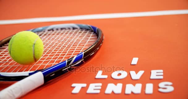 Pelota de tenis y raqueta con Me encanta el texto de tenis en la pista — Vídeo de stock