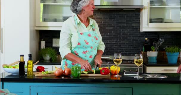 Couple sénior couper des légumes dans la cuisine — Video