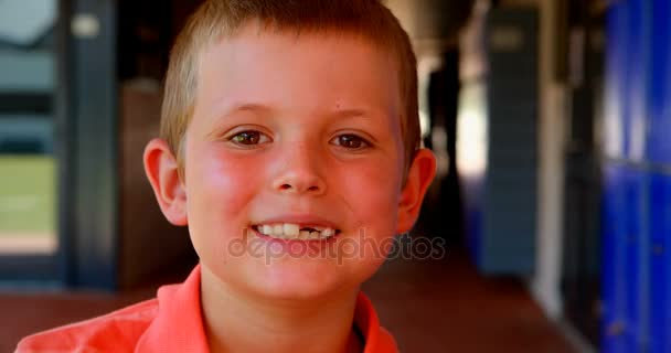 Cute schoolboy standing in corridor — Stock Video