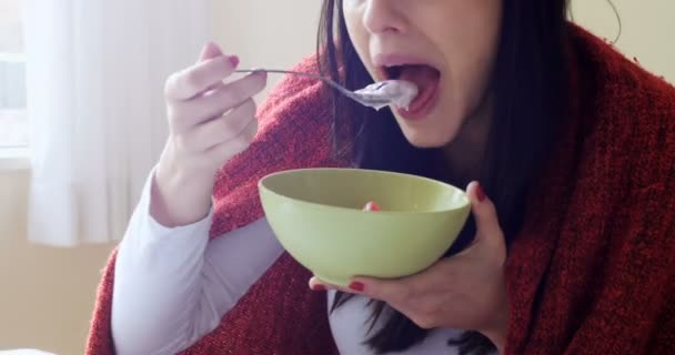 Femme utilisant un ordinateur portable tout en prenant le petit déjeuner — Video