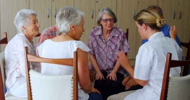 Kvinnliga läkare interagera med äldre människor — Stockvideo
