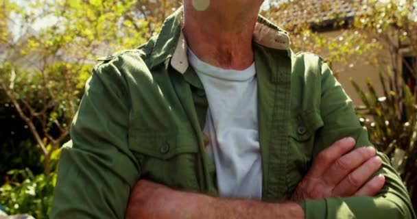 Portret van senior man permanent met gekruiste armen — Stockvideo