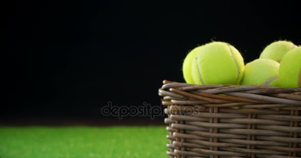 Pelotas de tenis en canasta de mimbre en el estudio — Vídeo de stock