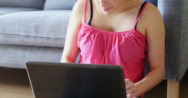 Hermosa mujer usando el ordenador portátil en la sala de estar — Vídeos de Stock