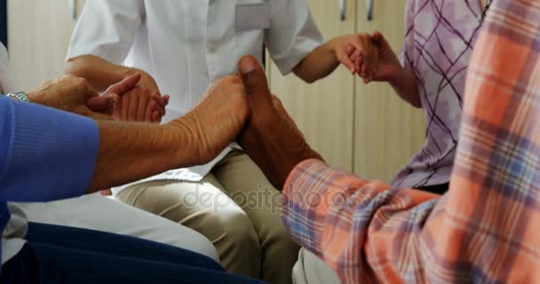 Seniorer och läkare som håller hand — Stockvideo