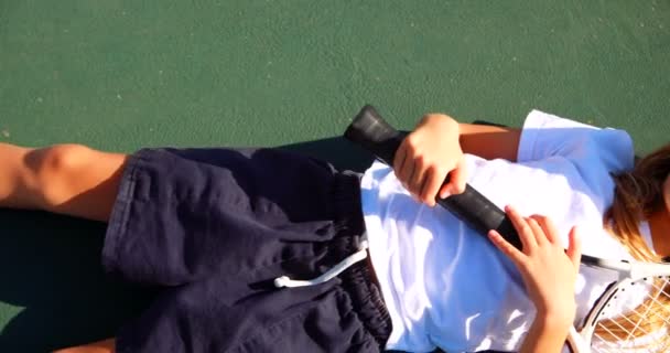 Skolflicka avkopplande i tennisbana — Stockvideo