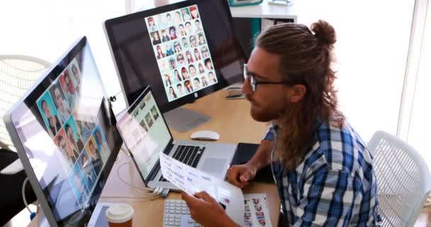 オフィスの彼の机でラップトップとグラフィックタブレットの上で働く男性役員 — ストック動画