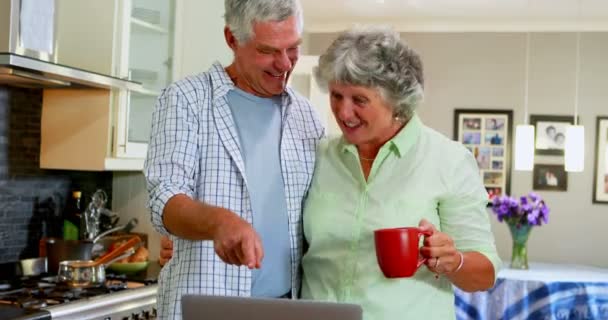 Ανώτερος ζευγάρι χρησιμοποιώντας φορητό υπολογιστή ενώ έχοντας καφέ — Αρχείο Βίντεο