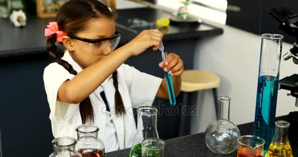 Школярка вивчає хімічну речовину в лабораторії — стокове відео
