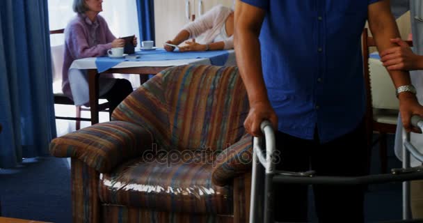 Médecin aidant l'homme âgé à marcher avec des marchettes pliantes — Video