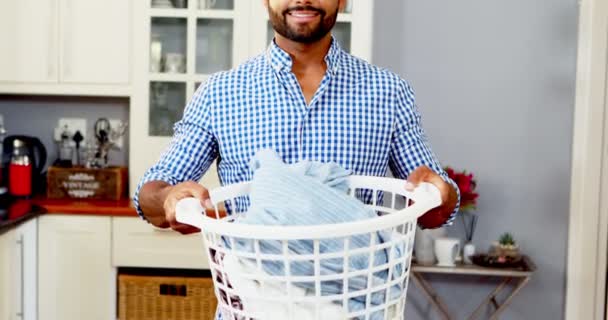 Retrato de hombre feliz sosteniendo cubo lleno de ropa — Vídeo de stock