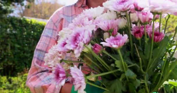 Mulher sênior segurando um monte de flores — Vídeo de Stock