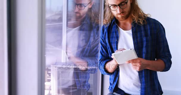 Ejecutivo masculino usando tableta digital cerca de ventana — Vídeo de stock