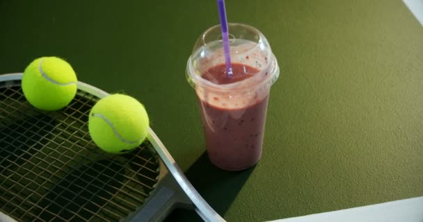 Молочний коктейль і спортивне обладнання в тенісному корті — стокове відео