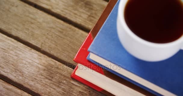 Чёрный кофе на стопке книг — стоковое видео