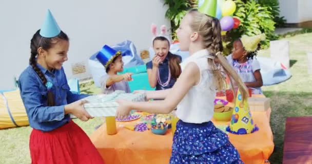Щасливі друзі грають з подарунковою коробкою — стокове відео