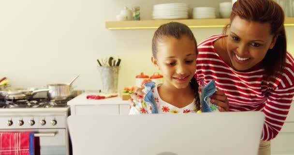 Μητέρα και κόρη που χρησιμοποιούν φορητό υπολογιστή στο πάγκο της κουζίνας — Αρχείο Βίντεο