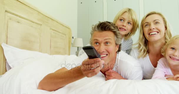 Familia viendo la televisión en el dormitorio — Vídeos de Stock