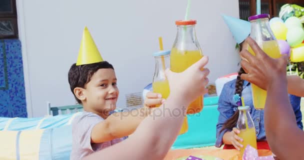 Amigos tostando botellas de jugo — Vídeos de Stock