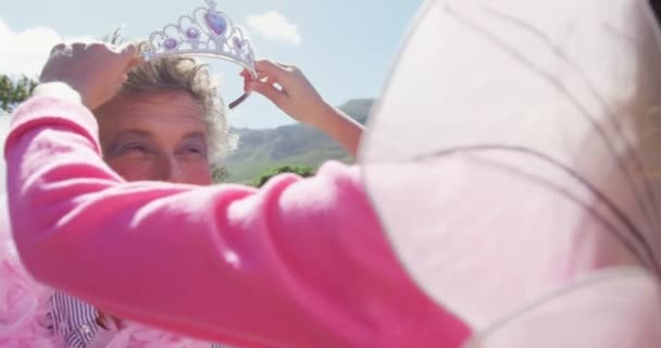 Hija en traje colocando corona en la cabeza de los padres — Vídeos de Stock