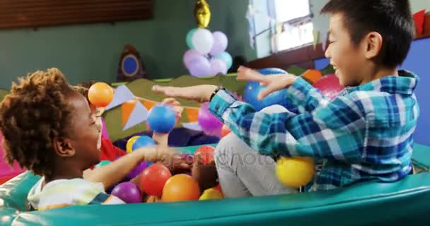 Niños jugando juntos en la piscina de pelota — Vídeo de stock