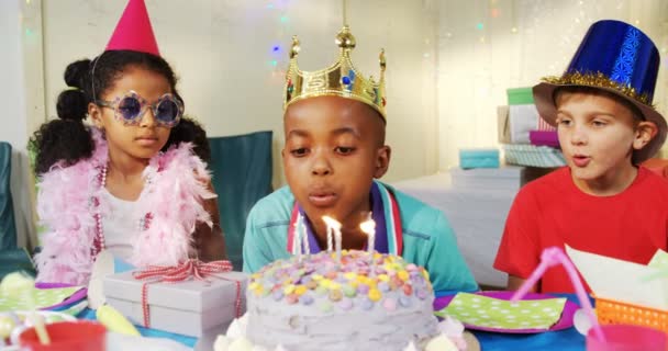 Menino soprando velas no bolo durante o aniversário — Vídeo de Stock
