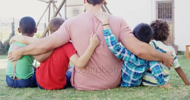 Man met kinderen zitten in de achtertuin van het huis — Stockvideo