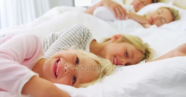 Crianças relaxando na cama enquanto os pais dormem — Vídeo de Stock