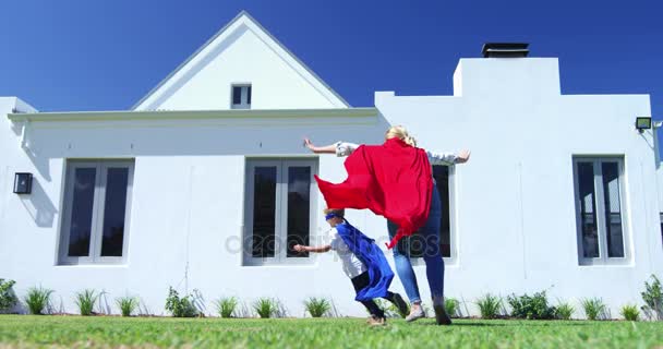 Mother and son in superhero costume having fun in garden — Stock Video