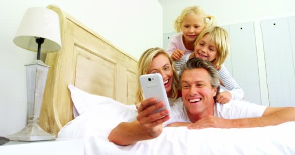 Familia tomando una selfie en el teléfono móvil en el dormitorio — Vídeo de stock