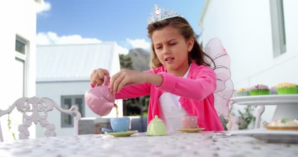 Дівчина в казковому костюмі наливає чай в чашку — стокове відео