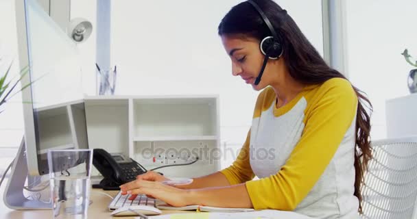 Executivo de negócios com fones de ouvido usando computadores na mesa no escritório 4k — Vídeo de Stock
