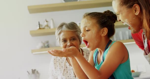 Famille soufflant la farine dans la cuisine — Video