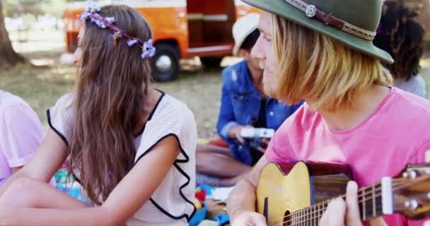 Homem tocando guitarra para seus amigos em um festival de música — Vídeo de Stock