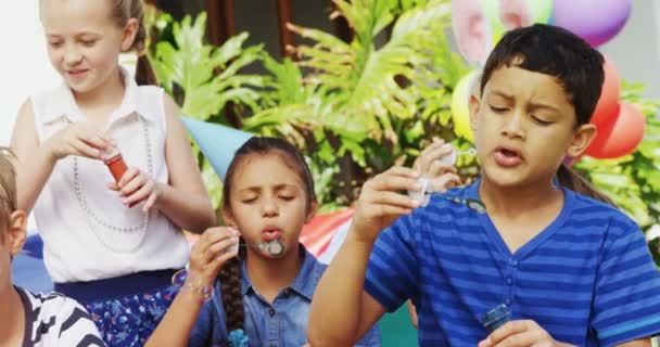 Amigos brincando com varinha de bolha no quintal — Vídeo de Stock