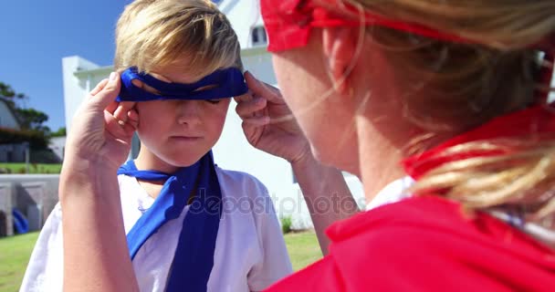 Μητέρα προσαρμογή μάσκα του γιου της στον κήπο — Αρχείο Βίντεο