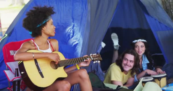Mujer tocando la guitarra para sus amigos en un festival de música — Vídeo de stock