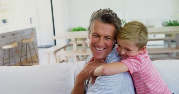 Happy father and son relaxing on sofa in living room — Stock Video