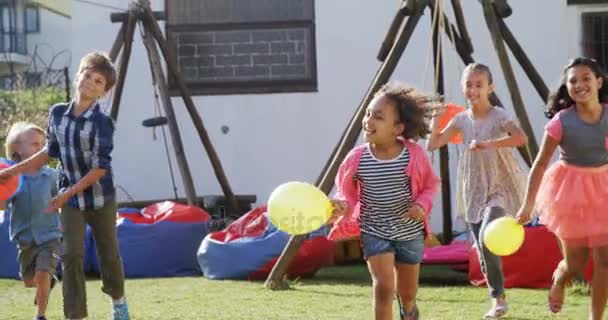 Счастливые друзья играют на заднем дворе — стоковое видео